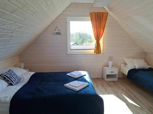 sypialnia z 2 łóżkami i oknem w obiekcie Błękitne Zamorze w mieście Niechorze