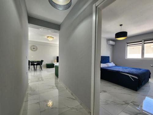 a bedroom with a blue bed and a dining room at Amazing Sea View Apartment in Sarandë