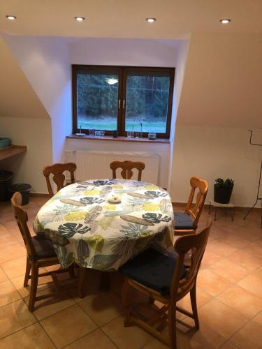 ein Esszimmer mit einem Tisch, Stühlen und einem Fenster in der Unterkunft Ferienwohnung Edmaier in Riedenburg