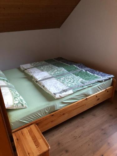 a twin bed in a room with a wooden floor at Ferienwohnung Edmaier in Riedenburg