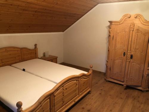 a bedroom with two beds and a wooden cabinet at Ferienwohnung Edmaier in Riedenburg