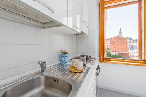 a kitchen with a sink and a window at Apartment San Giovanni - Sea View in Rovinj