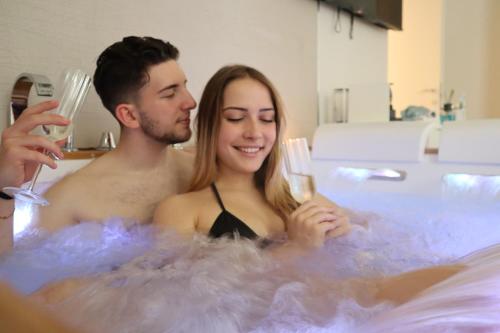 een man en een vrouw in een bad met wijnglazen bij Enjoyhousebracciano suite1 in Bracciano