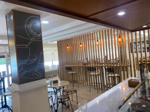 un restaurante con un bar con mesas y sillas en Hostal Restaurante Río Ubierna, en Quintanilla-Vivar