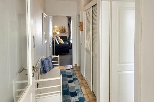 een hal met een witte deur en een blauwe vloer bij Gmelinstra_e 12_ Whg_ 18_ Haus Mee in Wyk auf Föhr