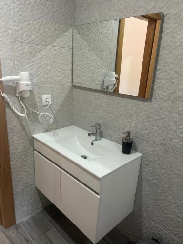 La salle de bains est pourvue d'un lavabo blanc et d'un miroir. dans l'établissement Casa Gidelos, à Gerês