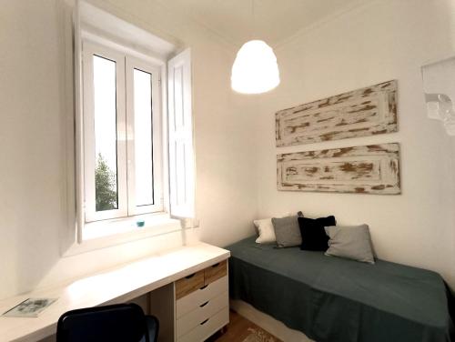 um quarto com uma cama e uma janela em 10 MARIA - Faro em Faro