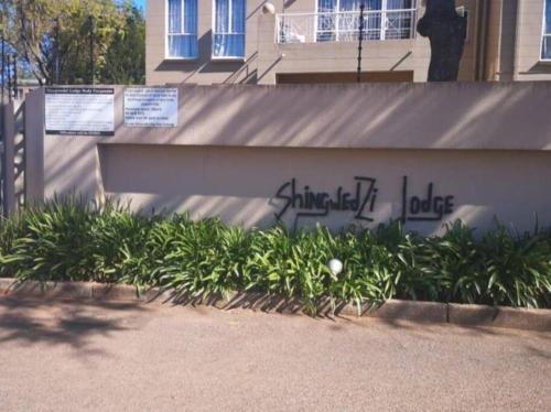 a wall with graffiti on it next to some plants at Fully Furnished 3 bedroom apartment rental in Roodepoort