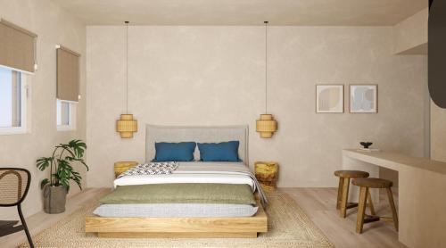 a bedroom with a large bed with blue pillows at Princess Luxury Suites Adults Only - Princess Hotels Collection in Agia Anna Naxos