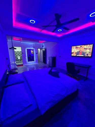 a blue room with a bed with a ceiling fan at Splash Bar and Guesthouse in Pattaya Central