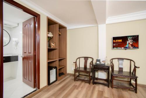 a living room with two chairs and a table at SAZI BEN THANH Hotel HCM in Ho Chi Minh City