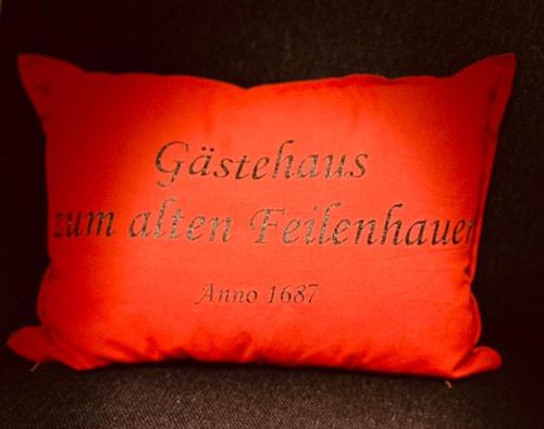 a red pillow with the words christiansithsxiaxiaxiaxiaxiaxia often at Gästehaus zum Alten Feilenhauer in Remscheid