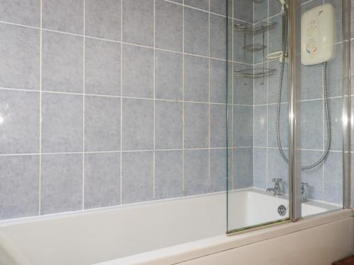 a bathroom with a shower and a bath tub at Beachcliff in Gorran Haven