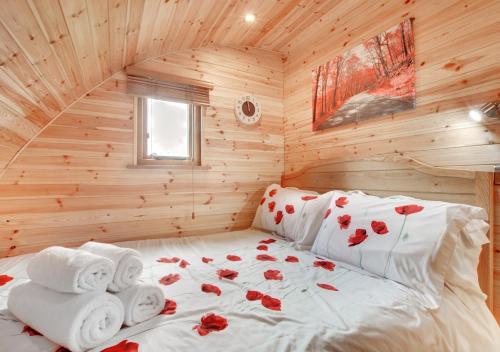 a bed in a log cabin with towels on it at Oak View in Llanddeusant