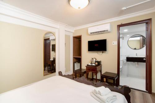 a hotel room with a bed and a mirror at SAZI BEN THANH Hotel HCM in Ho Chi Minh City