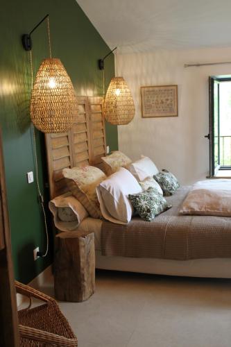 a bedroom with a bed with pillows and two lamps at La Demeure des Maitres in Chirols