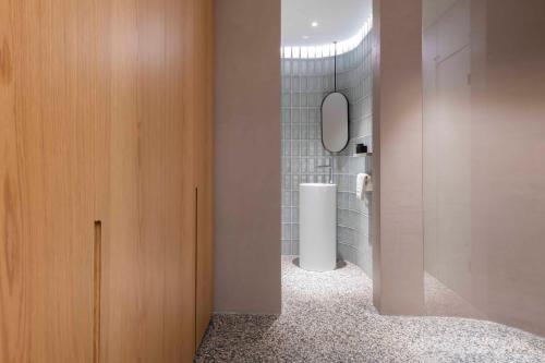 a bathroom with a toilet and a wooden cabinet at Gozo Harbour Views, Mgarr Heights in Mġarr