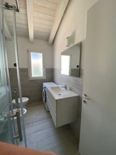 La salle de bains est pourvue d'un lavabo, de toilettes et d'un miroir. dans l'établissement Villetta 6 La Caletta, à La Caletta