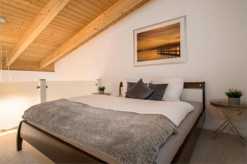 een slaapkamer met een groot bed en een houten plafond bij Ferienwohnung Zwischen den Seen in Vietzen