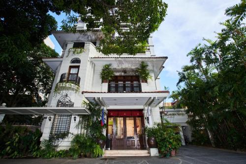 a tall white building with a red door at Orchid Garden Suites in Manila