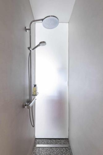 a shower in a bathroom with a white wall at Gozo Harbour Views, Mgarr Heights in Mġarr