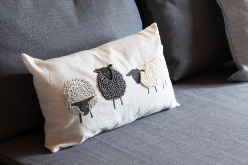 a pillow with four birds on it sitting on a couch at Waenfechan Glamping with Hot Tubs in Colwyn Bay