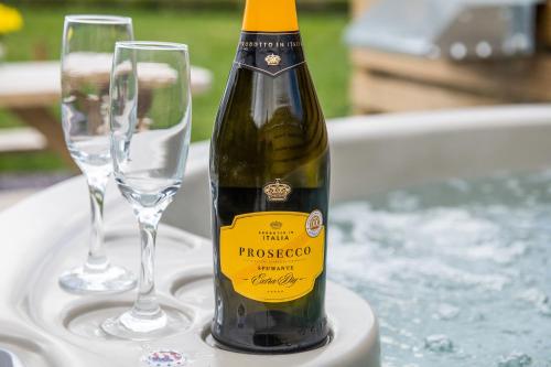a bottle of champagne and two glasses on a table at Waenfechan Glamping with Hot Tubs in Colwyn Bay