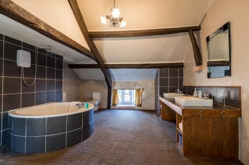 La grande salle de bains est pourvue d'une baignoire et de deux lavabos. dans l'établissement Gosforth Hall Inn, à Gosforth