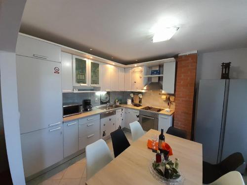 a kitchen with a table and a white refrigerator at Apartments Dalamar in Babino Polje