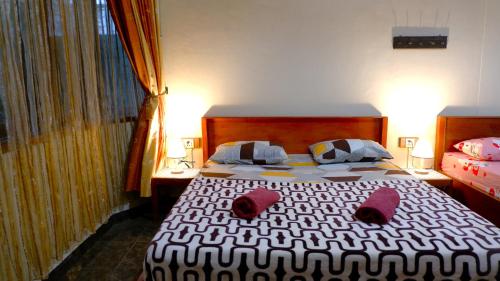 1 dormitorio con 1 cama con 2 almohadas en Sleepy Raccoon Hostel en Yogyakarta