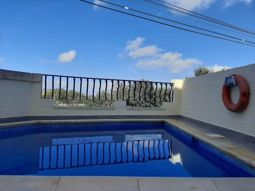 a swimming pool with blue water in front of a building at In-Nuffara Farmhouse, Nadur Gozo in Nadur