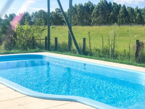 a blue swimming pool with a field in the background at Campo verde II in Concordia
