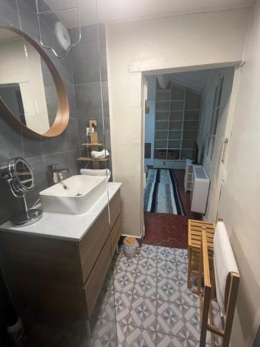 ein Bad mit einem Waschbecken und einem Spiegel in der Unterkunft Maison Arlette in Arles
