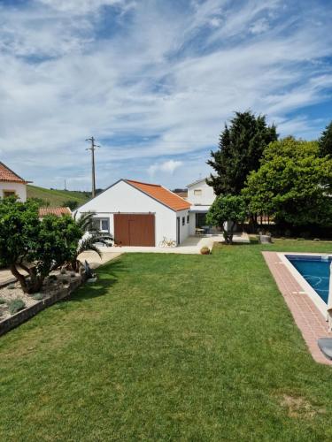 a backyard with a pool and a house at Casa Nikana in Turcifal