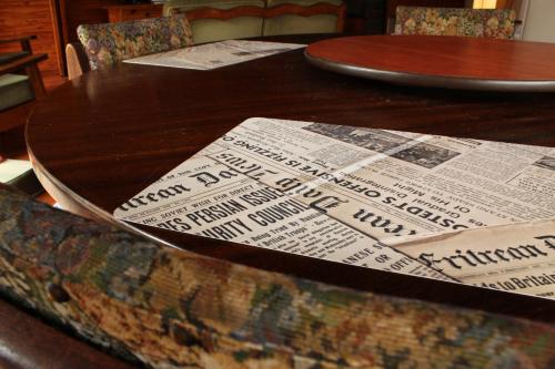 a wooden table with a newspaper on top of it at Serenity Graskop, 3 bedroom A-Frame cottage in Graskop