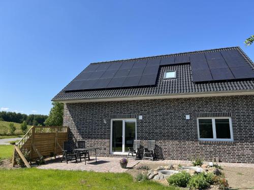 una casa con paneles solares en el techo en Ferienwohnungen EBBE und FLUT - Niedrigenergiehaus, en Elpersbüttel