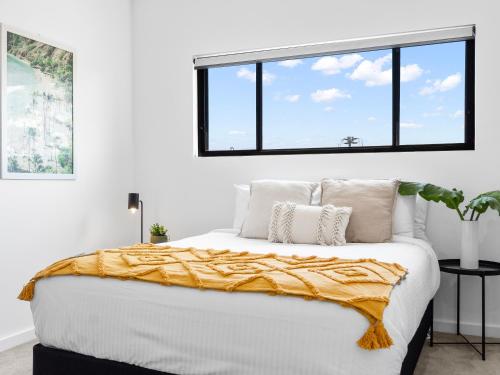 a bedroom with a large bed with a window at Palmera on the south coast in Ulladulla