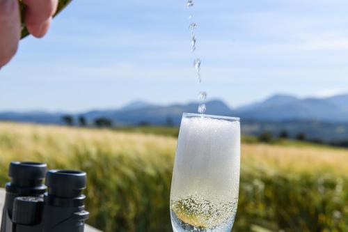 a person is pouring champagne into a wine glass at Waenfechan Glamping with Hot Tubs in Colwyn Bay