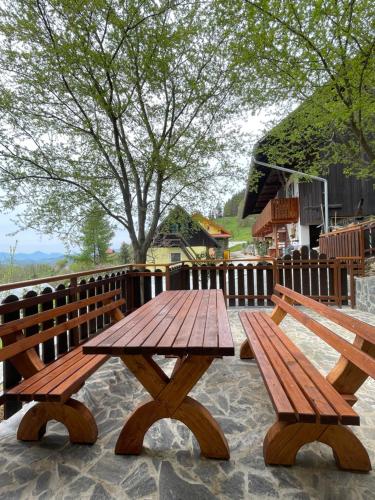 a wooden picnic table and benches on a patio at Boutique Tourist Farm Hrovat in Frankolovo