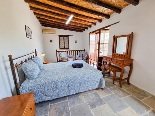 a bedroom with a bed and a table and a mirror at Aphrodite's Pool Retreat in Skarinou