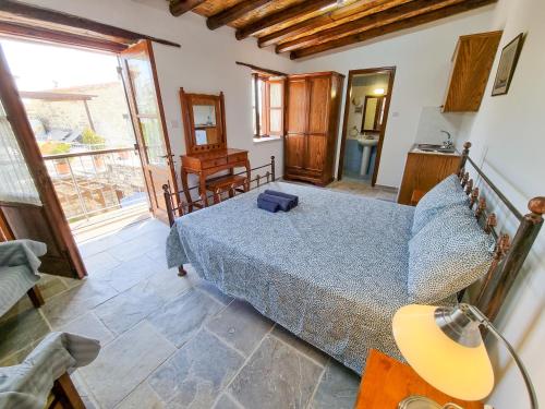 a bedroom with a bed and a large window at Aphrodite's Pool Retreat in Skarinou