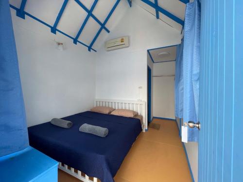 a small room with two beds and a blue curtain at Ko Phangan Beach Cottages in Baan Tai