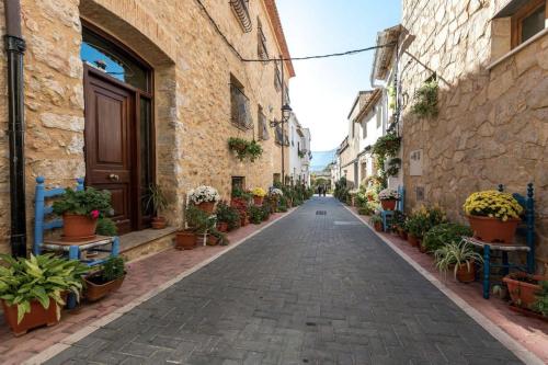 an empty street with potted plants in an alley at La Calma in Lliber