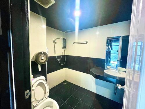 La petite salle de bains est pourvue de toilettes et d'un lavabo. dans l'établissement New Warm Light Hostel, à Chiang Mai