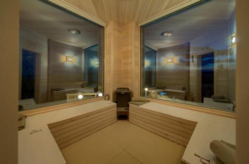 a bathroom with two large windows and a sink at Villa PIANO in Pinezici