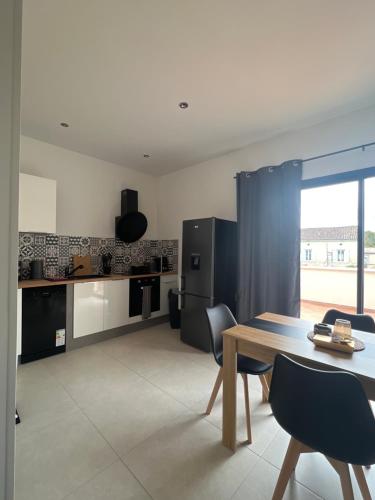 a kitchen and dining room with a table and chairs at Résidence Mk Evasion in Jonzac
