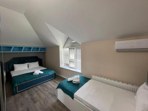 a small bedroom with two beds and a window at Qafqaz Paradise Villa in Gabala