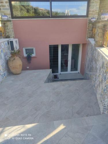 an empty patio with a large window and a building at Bed&Rooms Villa La Gatta in Vatolla