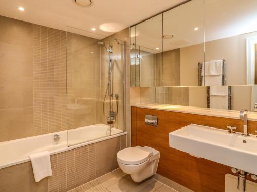 a bathroom with a sink and a toilet and a bath tub at 30 Dart Marina in Dartmouth