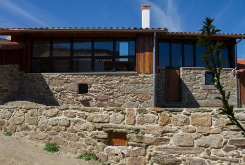 una casa con una pared de piedra en Casiñas do Sil, en Cristosende